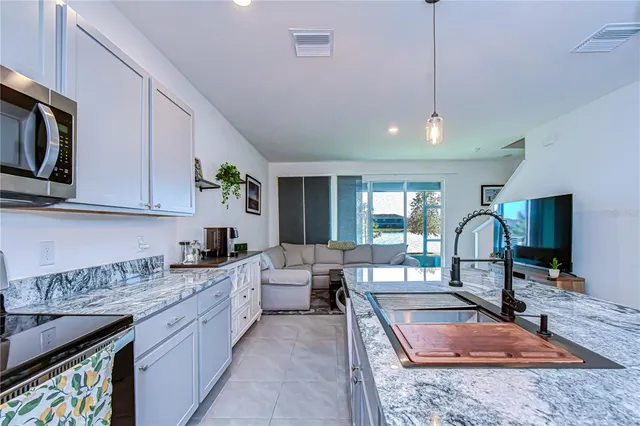 a kitchen with stainless steel appliances granite countertop a sink refrigerator and cabinets