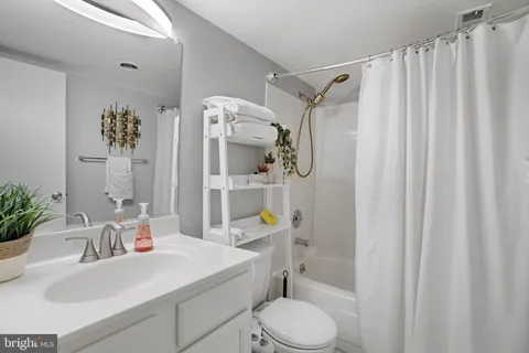 a bathroom with a sink a toilet and shower curtain