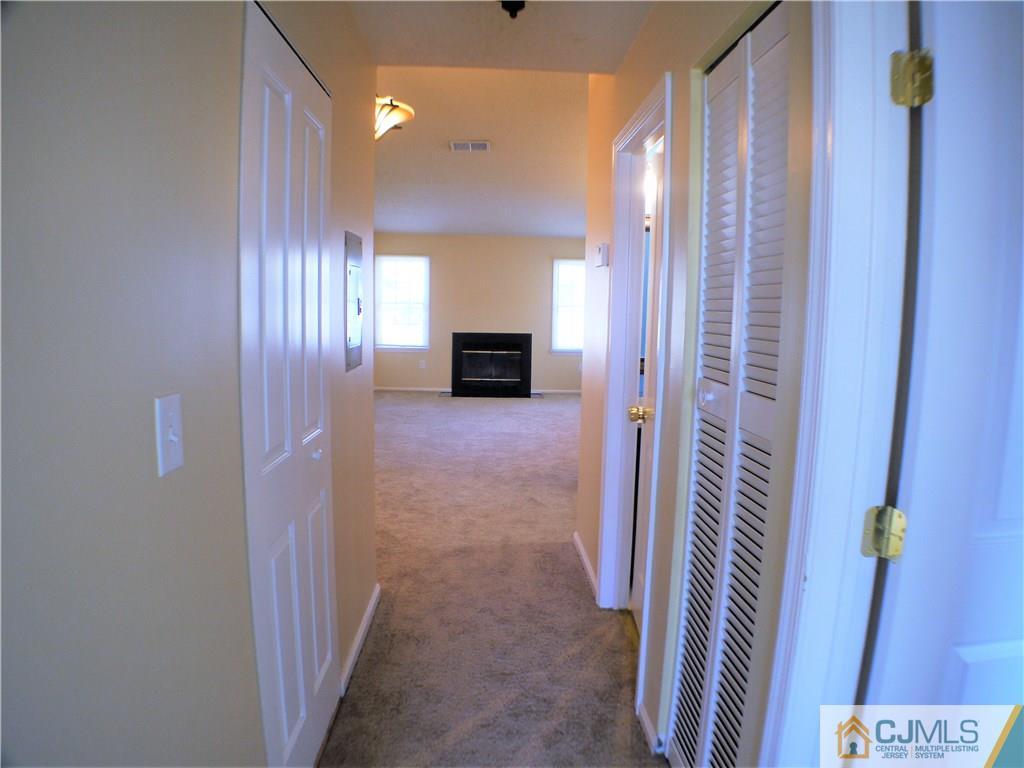 936 Edpas Road, Unit 936 New Brunswick, NJ 08901 - Photo 3 of 21 a view of a hallway with a livingroom and a fireplace