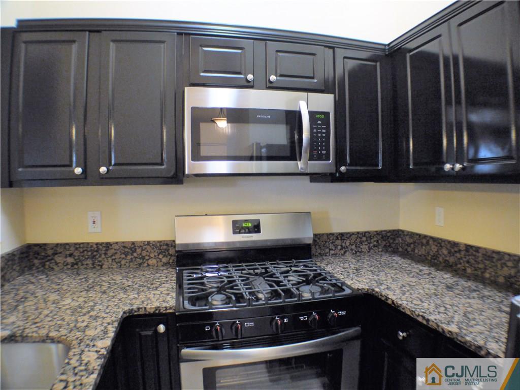 936 Edpas Road, Unit 936 New Brunswick, NJ 08901 - Photo 4 of 21 a kitchen with granite countertop a stove and a microwave