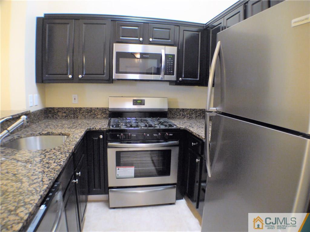 936 Edpas Road, Unit 936 New Brunswick, NJ 08901 - Photo 6 of 21 a kitchen with granite countertop a stove microwave and refrigerator