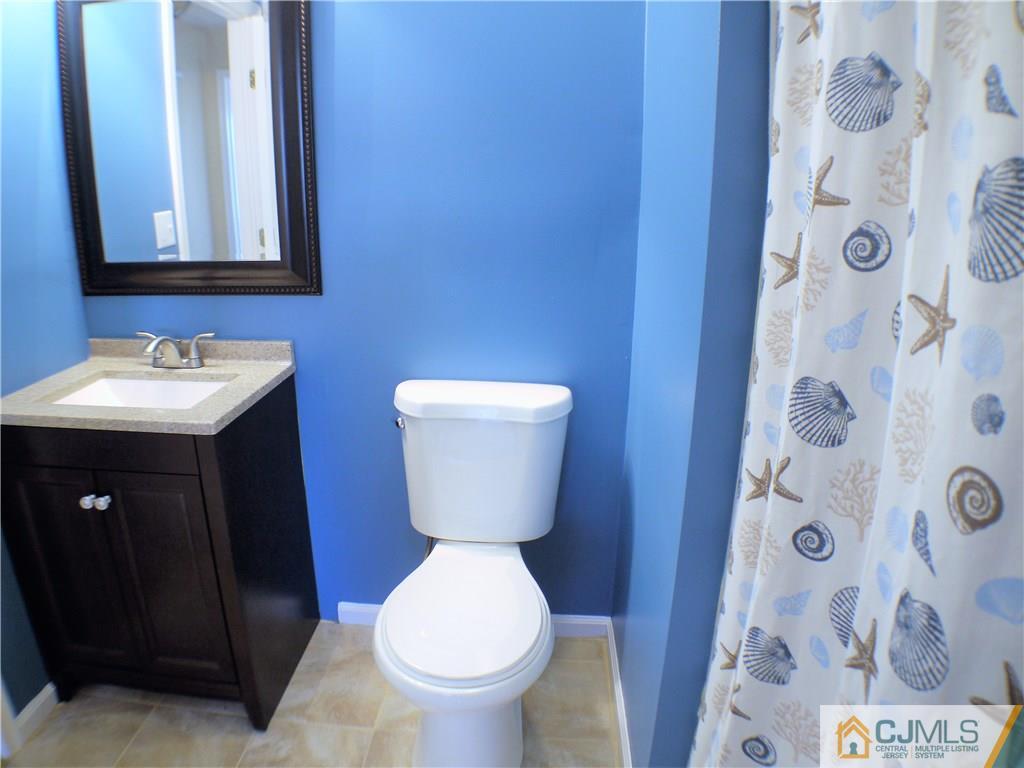936 Edpas Road, Unit 936 New Brunswick, NJ 08901 - Photo 10 of 21 a bathroom with a toilet sink and mirror