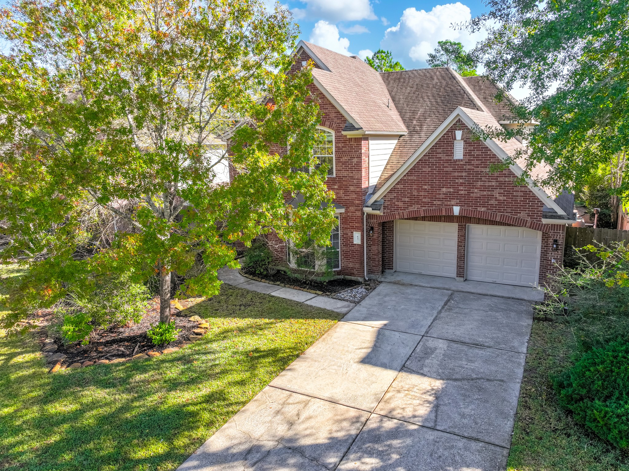 This charming two-story brick home features a spacious driveway leading to a double garage. Nestled among mature trees, the property offers a serene setting with well-maintained landscaping, providing both privacy and curb appeal.