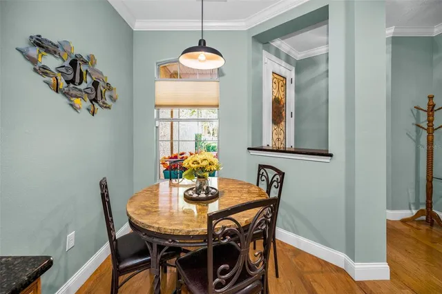 a kitchen with stainless steel appliances granite countertop a refrigerator a sink dishwasher a stove and white countertops with wooden floor