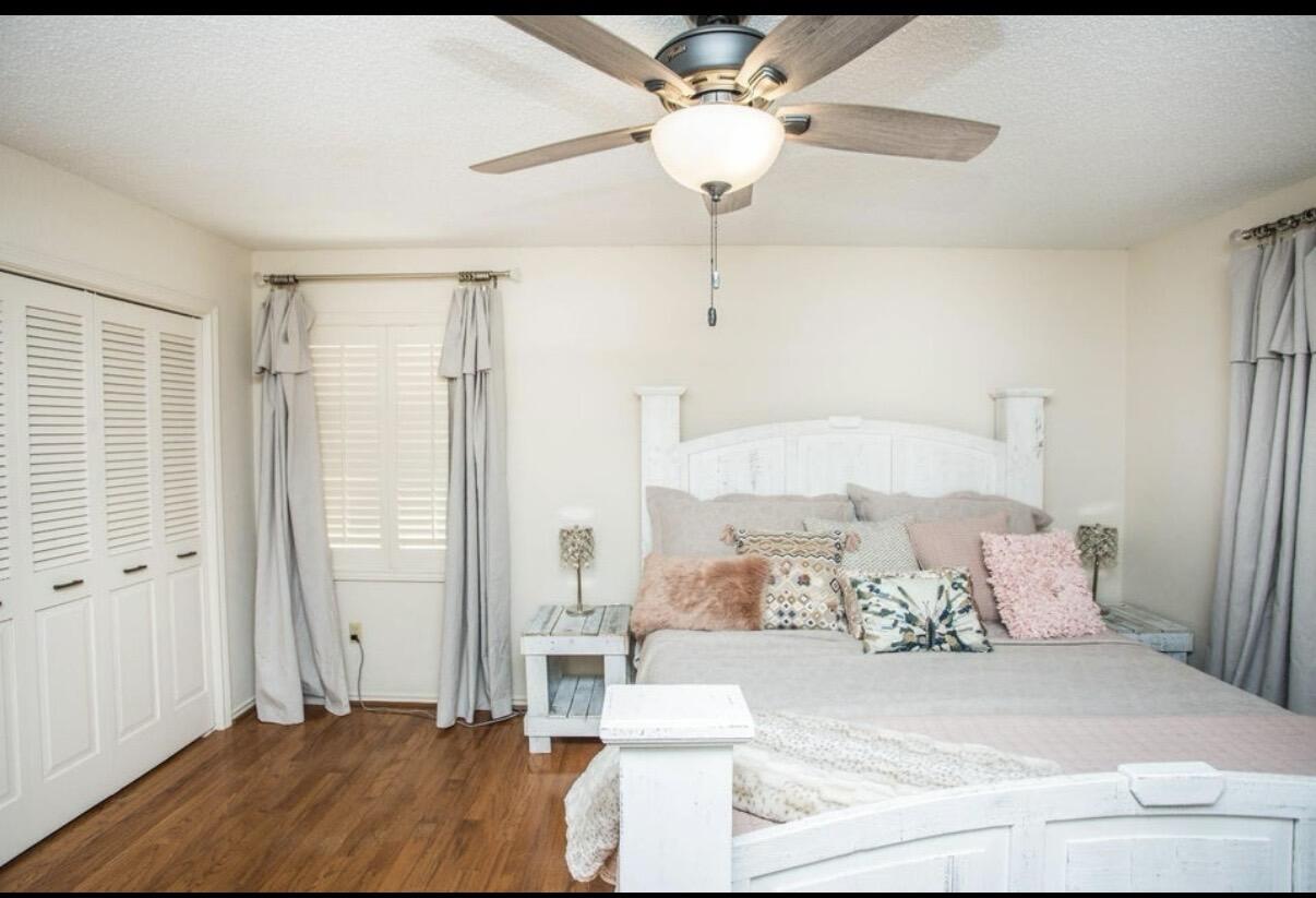 5202 20th Street Lubbock, TX 79407 - Photo 20 of 45 a bedroom with a large bed and a chandelier