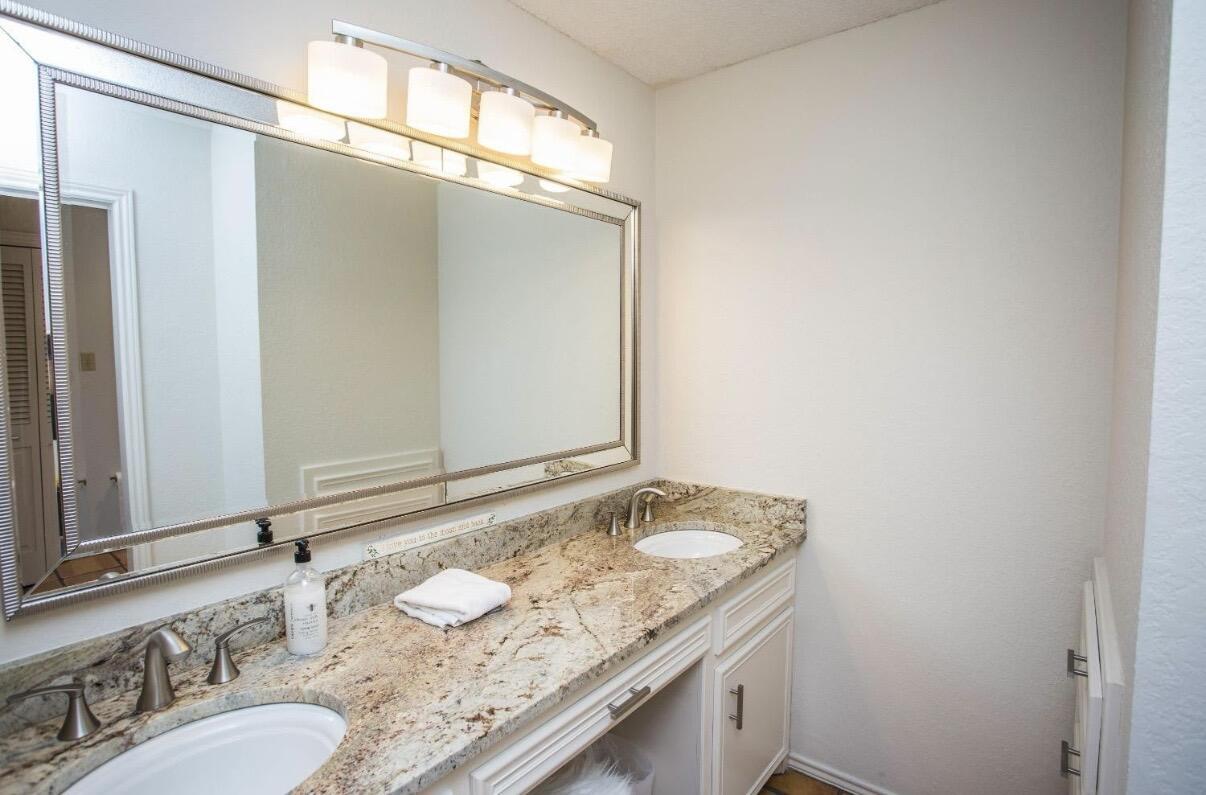 5202 20th Street Lubbock, TX 79407 - Photo 23 of 45 a bathroom with a granite countertop sink and a mirror