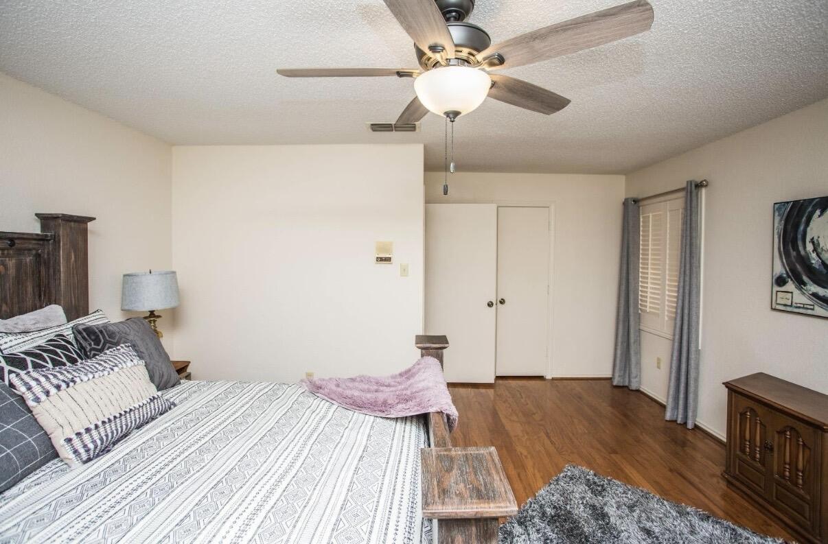 5202 20th Street Lubbock, TX 79407 - Photo 31 of 45 a bedroom with a bed and a chandelier