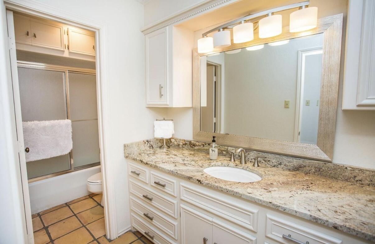 5202 20th Street Lubbock, TX 79407 - Photo 35 of 45 a bathroom with a granite countertop sink and a mirror