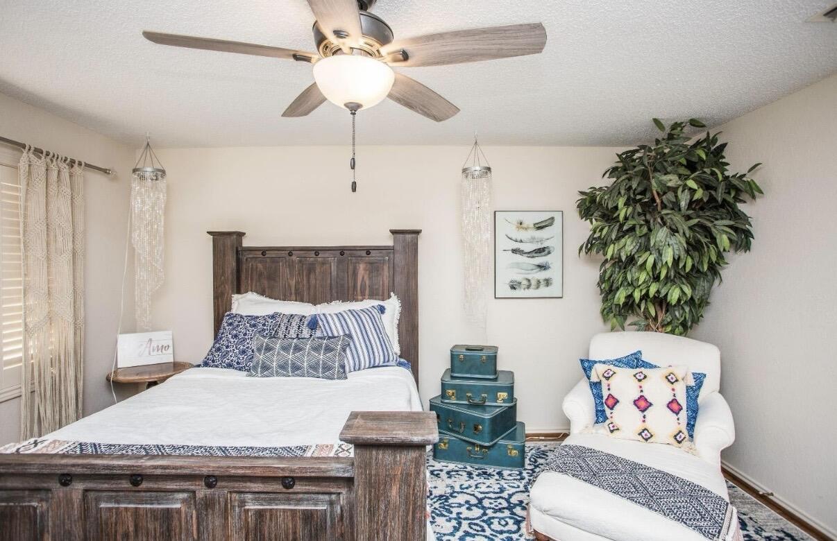 5202 20th Street Lubbock, TX 79407 - Photo 40 of 45 a bedroom with a bed and a chandelier