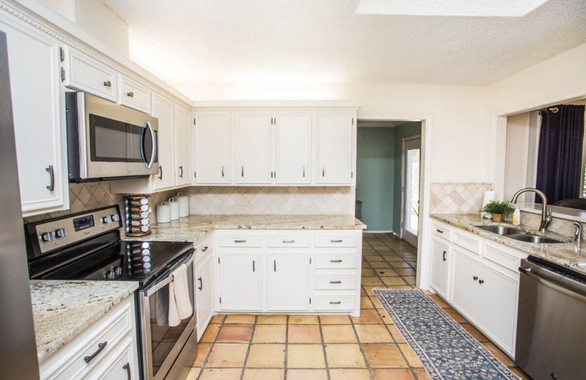 5202 20th Street Lubbock, TX 79407 - Photo 7 of 45 a kitchen with a sink stove and microwave