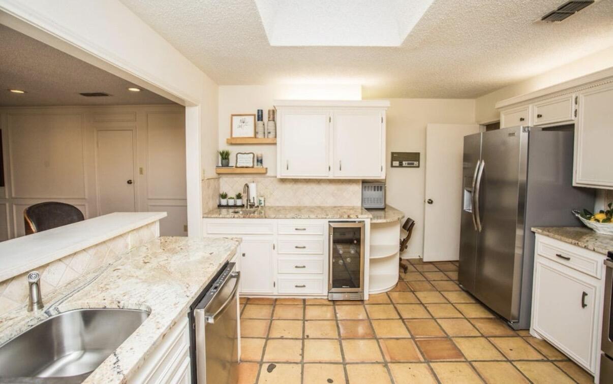 5202 20th Street Lubbock, TX 79407 - Photo 8 of 45 a kitchen with a stove a sink and a refrigerator