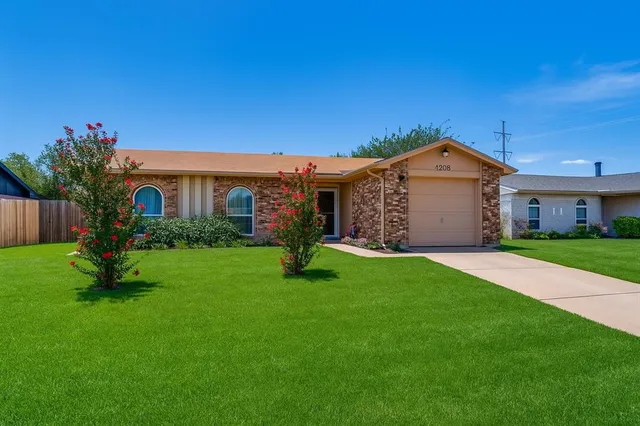 a front view of a house with a garden and yard