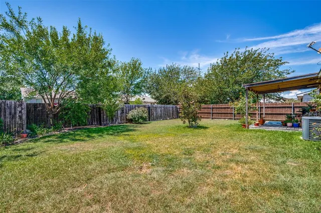 a backyard of a house with lots of green space and plants