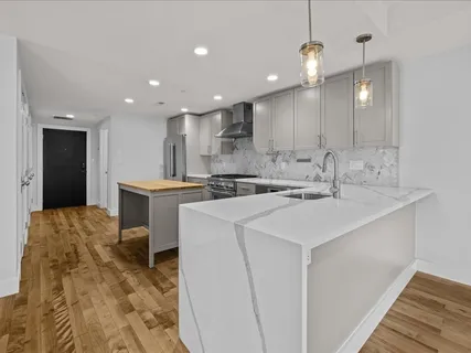 a kitchen with kitchen island a sink stainless steel appliances and white cabinets