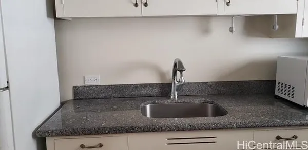 a kitchen with a sink and a wooden floor
