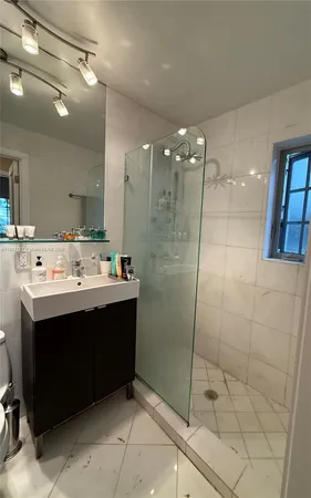 a bathroom with a sink mirror and shower