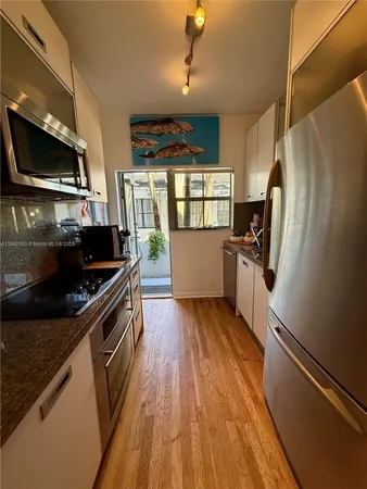 a kitchen with wooden floors and stainless steel appliances