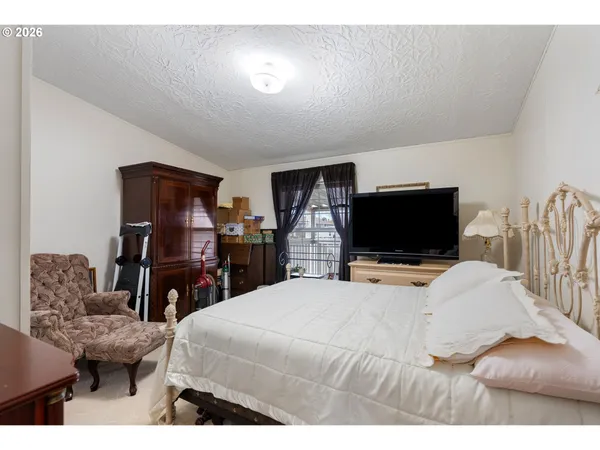 a bedroom with a bed and a flat screen tv