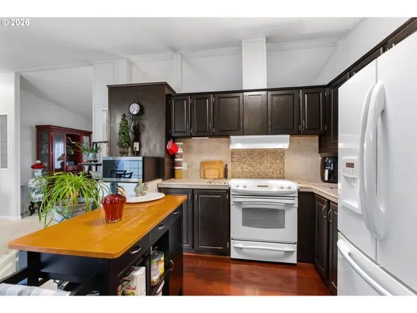 a kitchen with kitchen island a stove a refrigerator a sink and a refrigerator