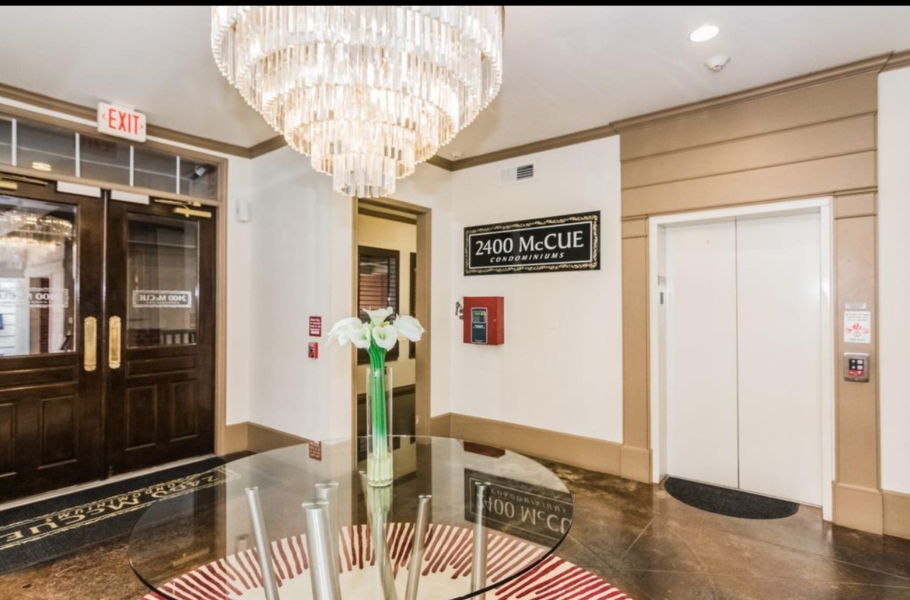 2400 McCue Road, Unit 262 Houston, TX 77056 - Photo 32 of 50 a view of a hallway with dining area and chandelier