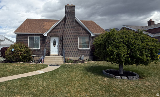 287 100 North Orem, UT 84057 - Photo 1 of 18 View of front of home featuring brick siding, roof with shingles, a front lawn, and a chimney