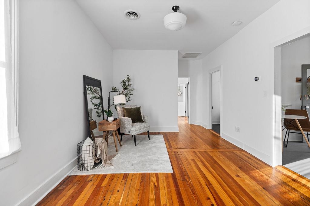 a view of a room with wooden floor and furniture