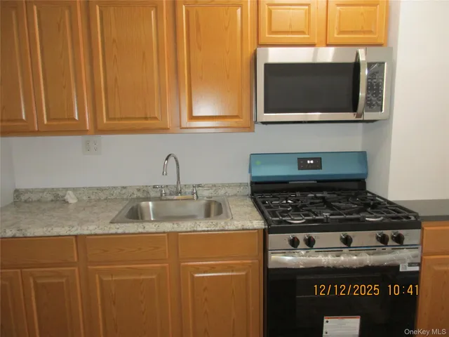 a kitchen with granite countertop stainless steel appliances a stove top oven