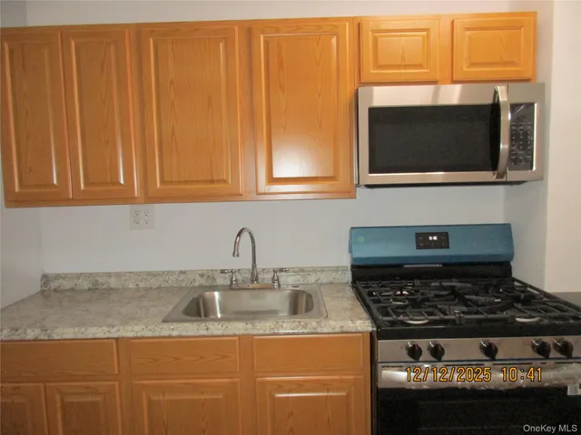 a kitchen with granite countertop a stove and a sink