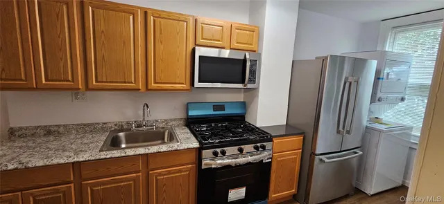 a kitchen with stainless steel appliances granite countertop a refrigerator and a stove top oven