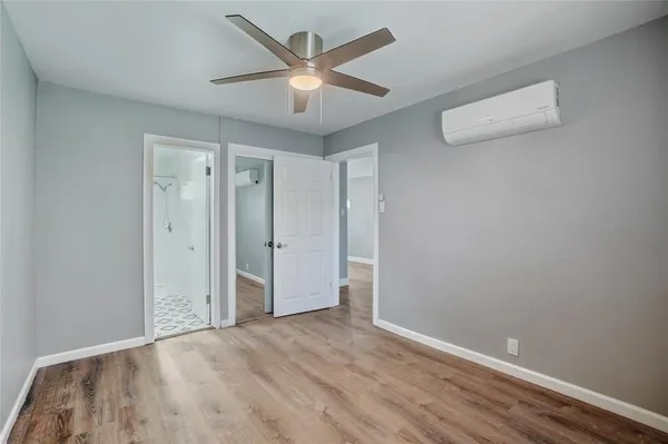 an empty room with wooden floor and ceiling fan