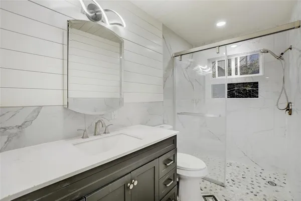 a bathroom with a sink a toilet and shower