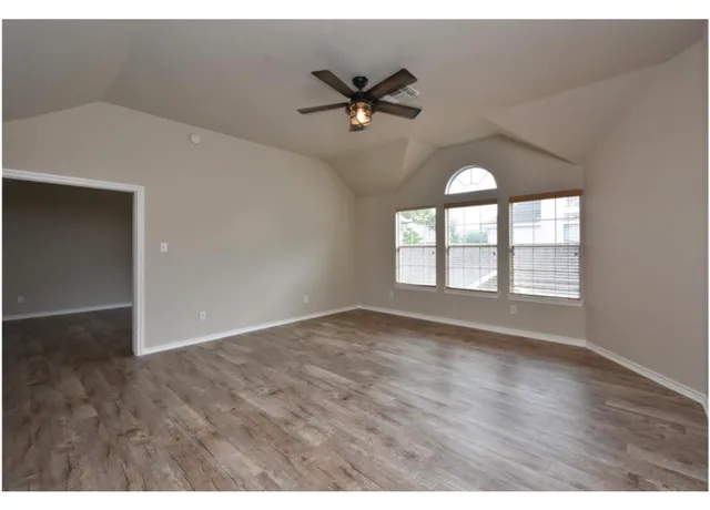 a view of a livingroom with wooden floor and a window