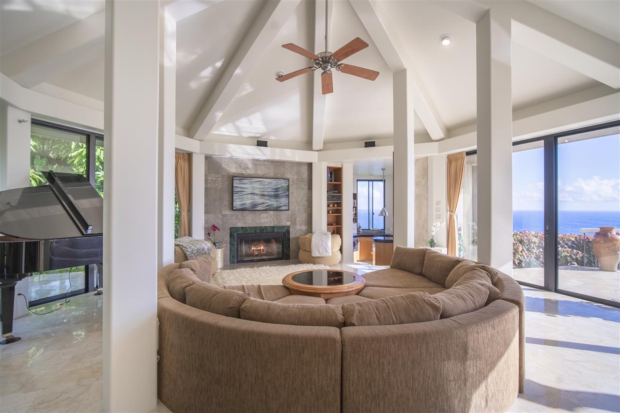 668 Huelo Road Haiku, HI 96708 - Photo 8 of 28 a living room with furniture a large window and a fireplace