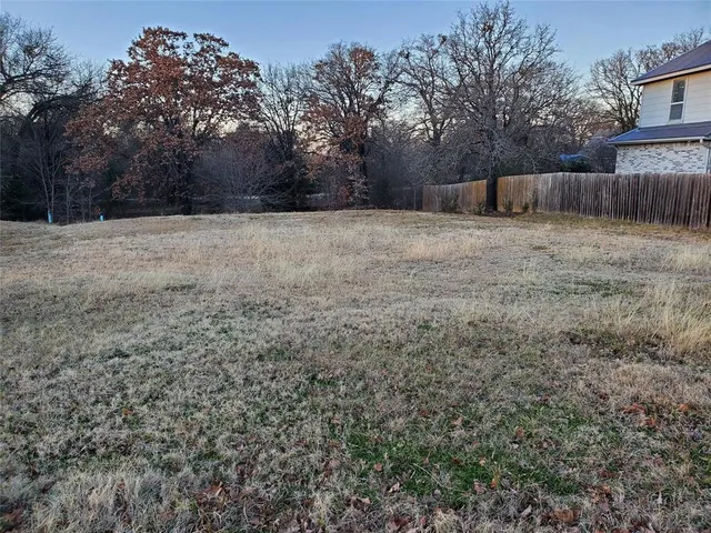a view of a backyard with large trees