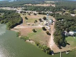 an aerial view of a house with a yard and lake view