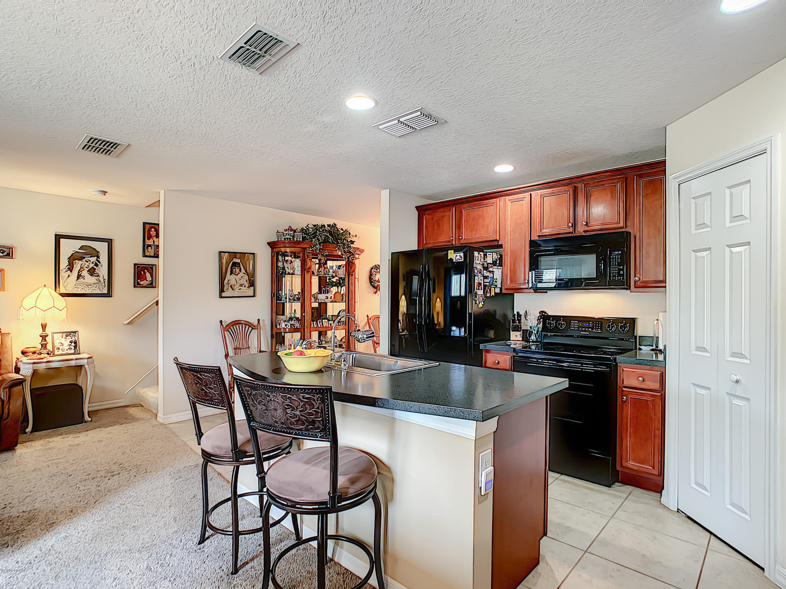 180 Tarracina Way Daytona Beach, FL 32117 - Photo 13 of 39 a kitchen with stainless steel appliances granite countertop a stove top oven a sink dishwasher and a refrigerator with wooden floor