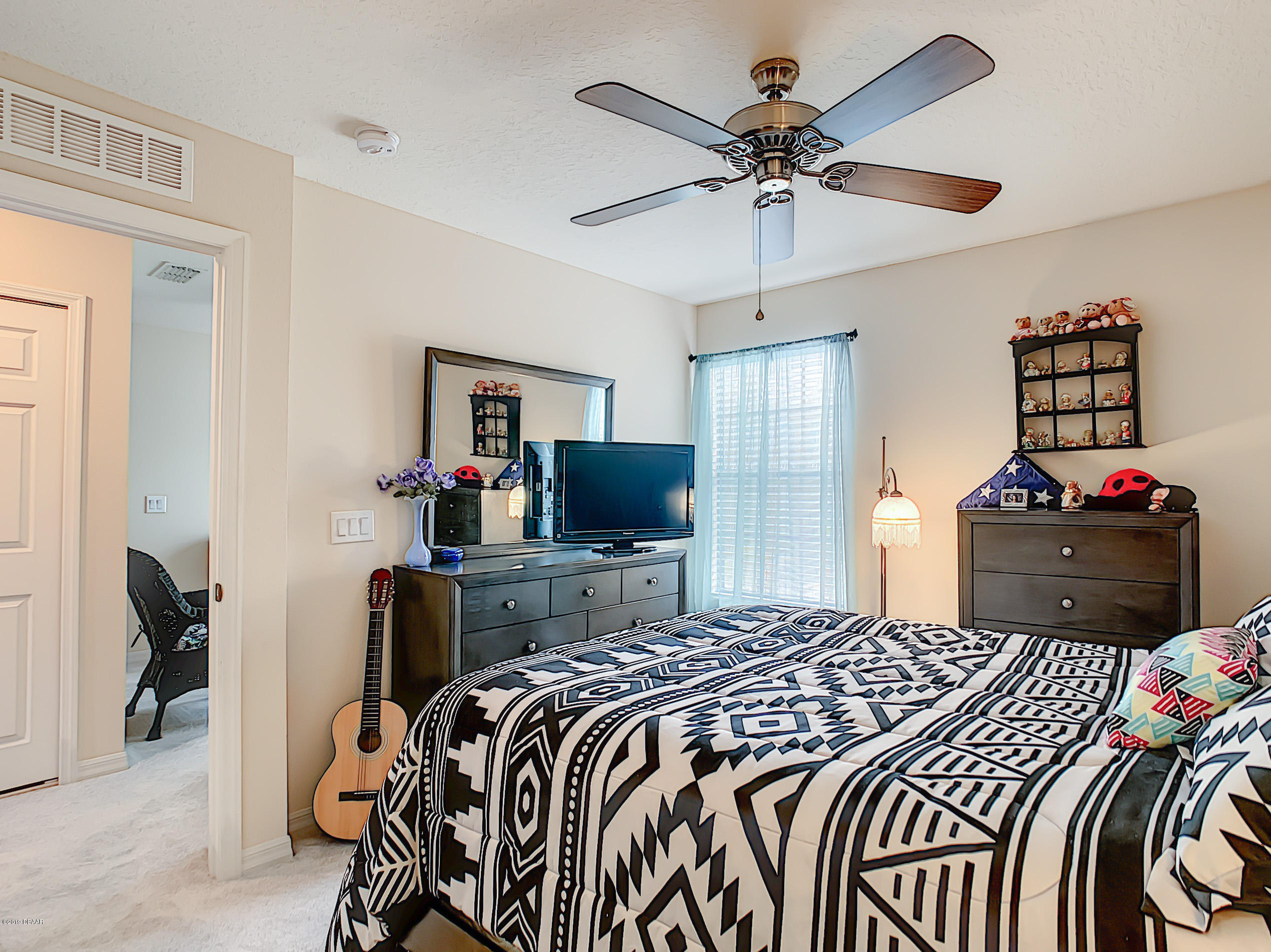 180 Tarracina Way Daytona Beach, FL 32117 - Photo 20 of 39 a bedroom with a bed and a chandelier