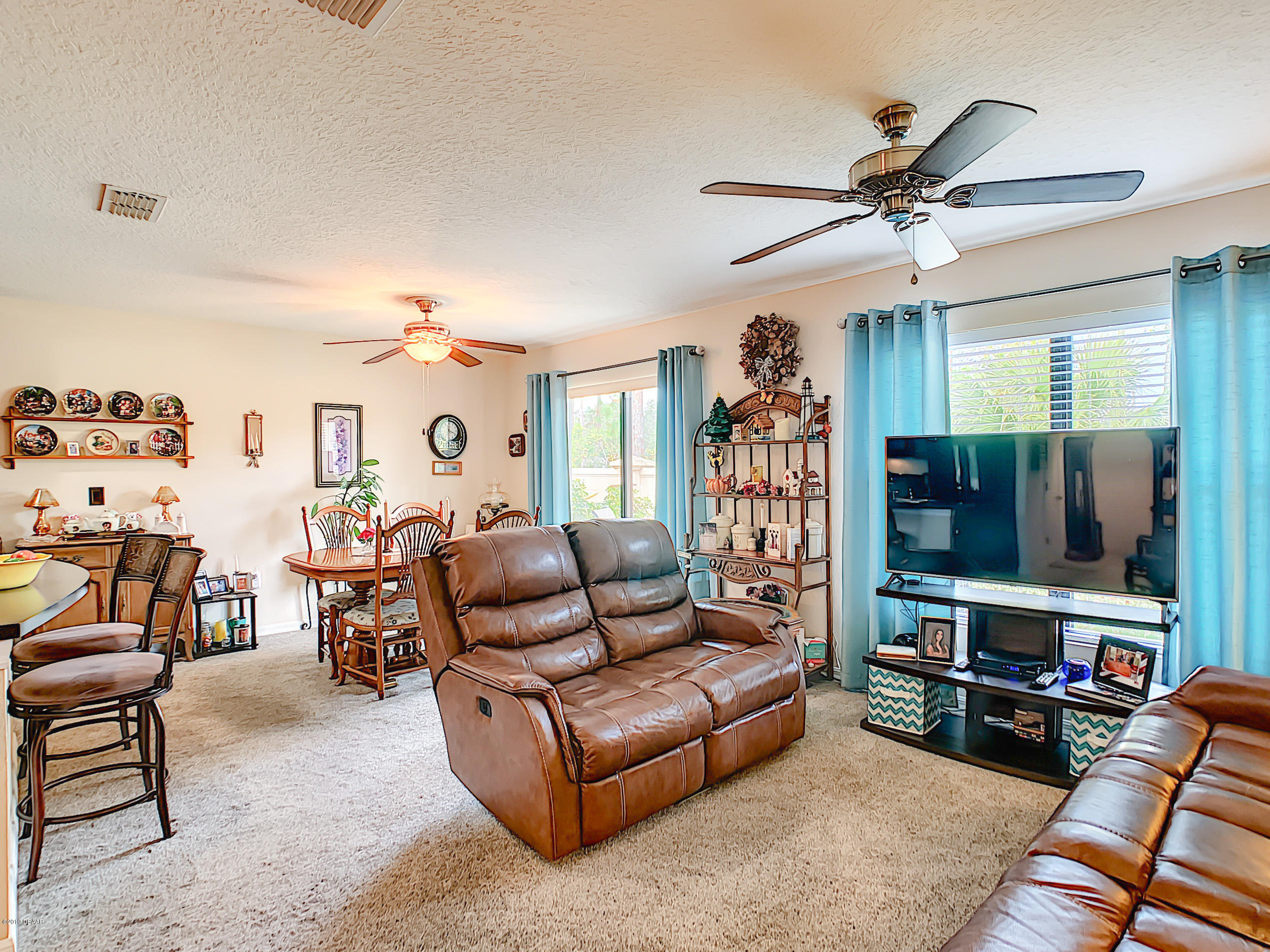 180 Tarracina Way Daytona Beach, FL 32117 - Photo 2 of 39 a living room with furniture a ceiling fan and a window