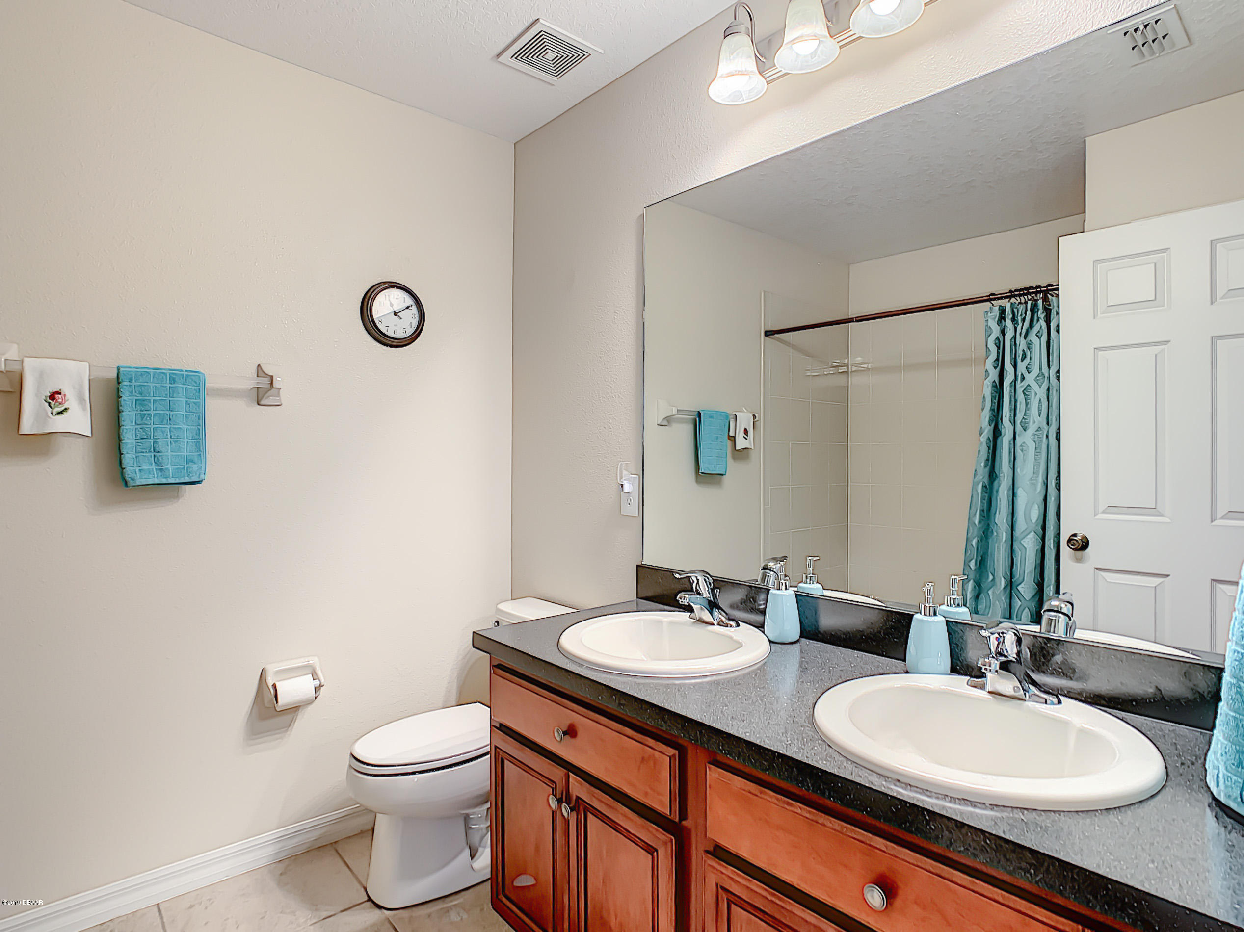 180 Tarracina Way Daytona Beach, FL 32117 - Photo 24 of 39 a bathroom with a granite countertop sink mirror vanity and toilet