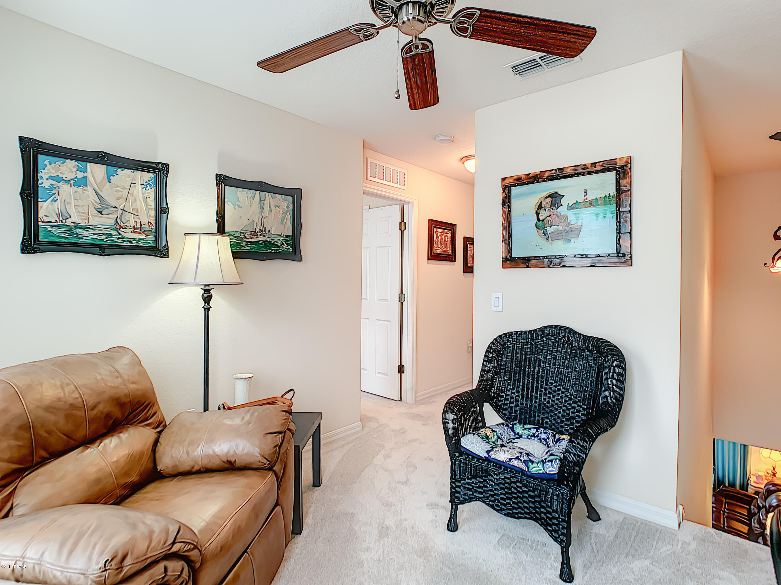 180 Tarracina Way Daytona Beach, FL 32117 - Photo 33 of 39 a living room with furniture a couch and a painting on the wall