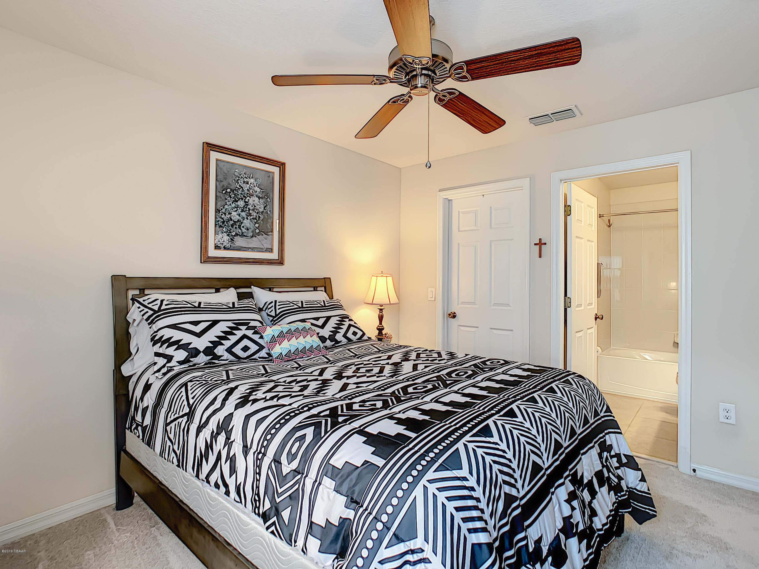 180 Tarracina Way Daytona Beach, FL 32117 - Photo 34 of 39 a bedroom with a large bed and a ceiling fan