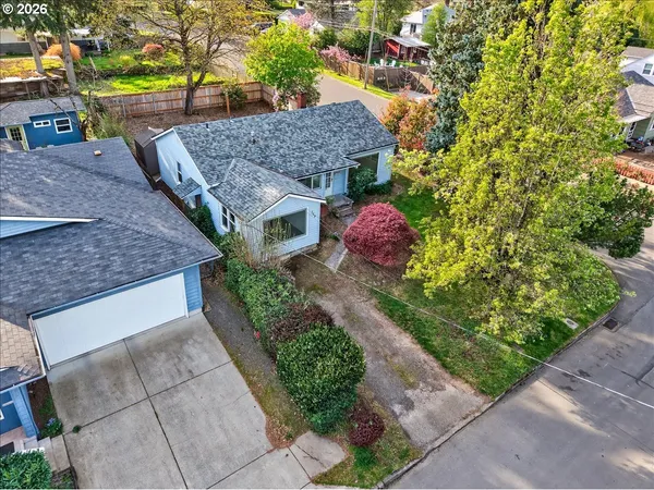 a aerial view of a house with a yard and large tree