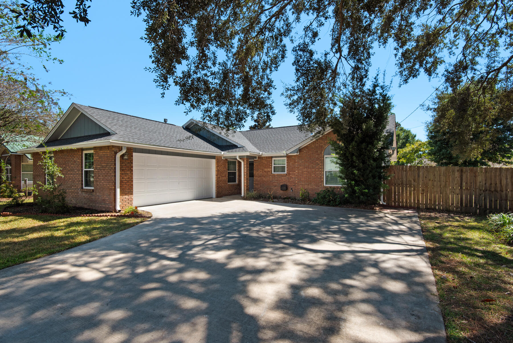 a view of a house with a yard and large tree