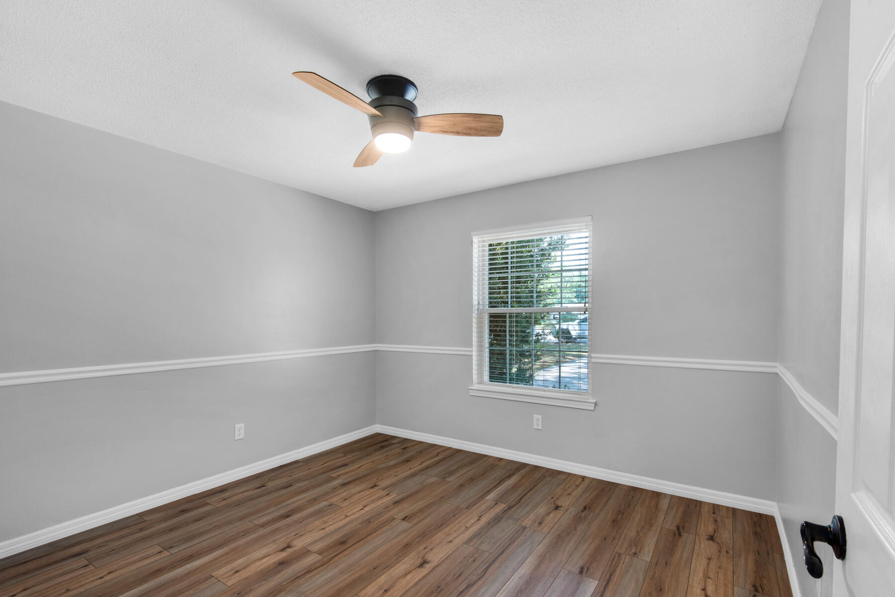 4022 13th Street Niceville, FL 32578 - Photo 30 of 37 an empty room with wooden floor fan and windows