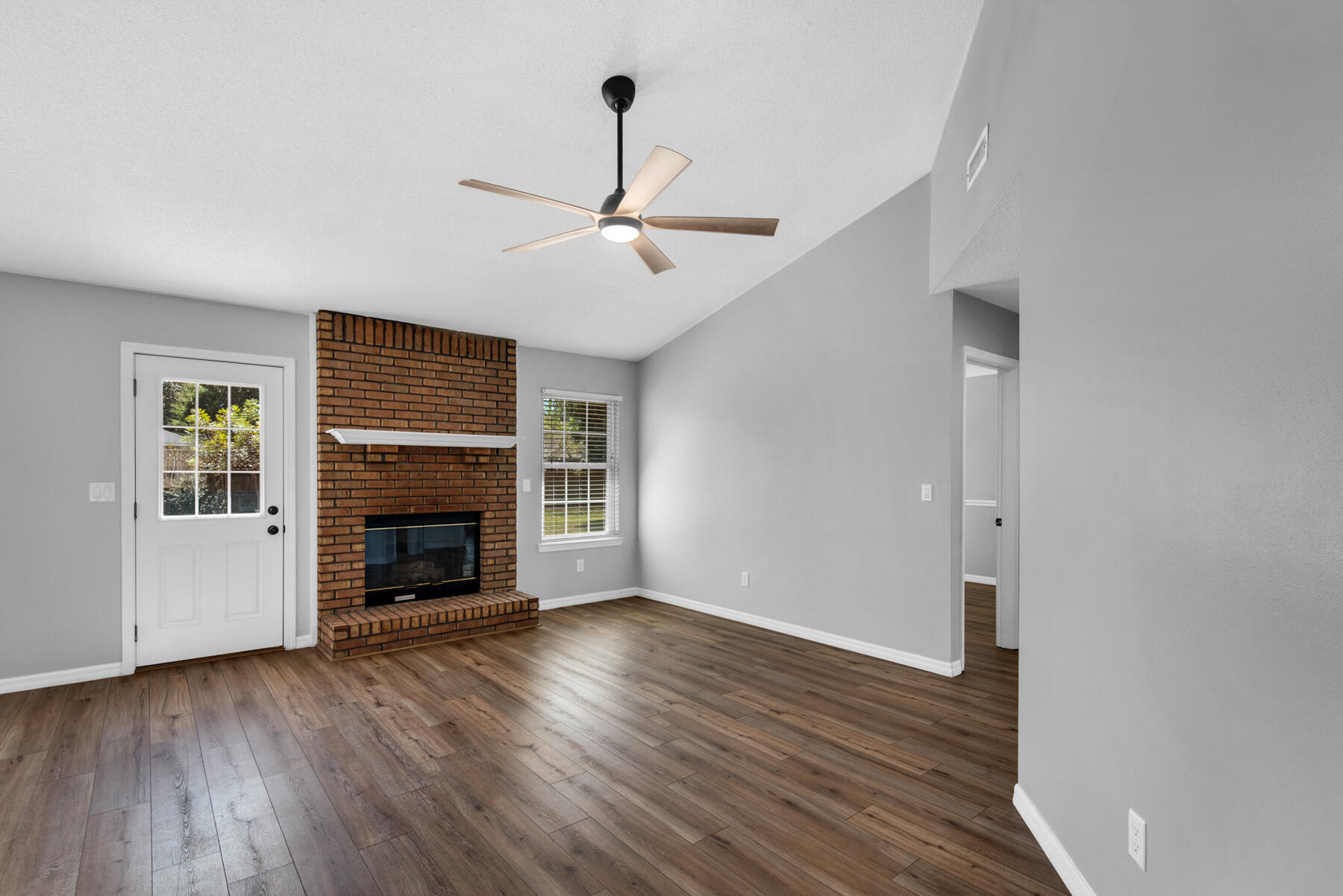 4022 13th Street Niceville, FL 32578 - Photo 6 of 37 an empty room with wooden floor fireplace and a window
