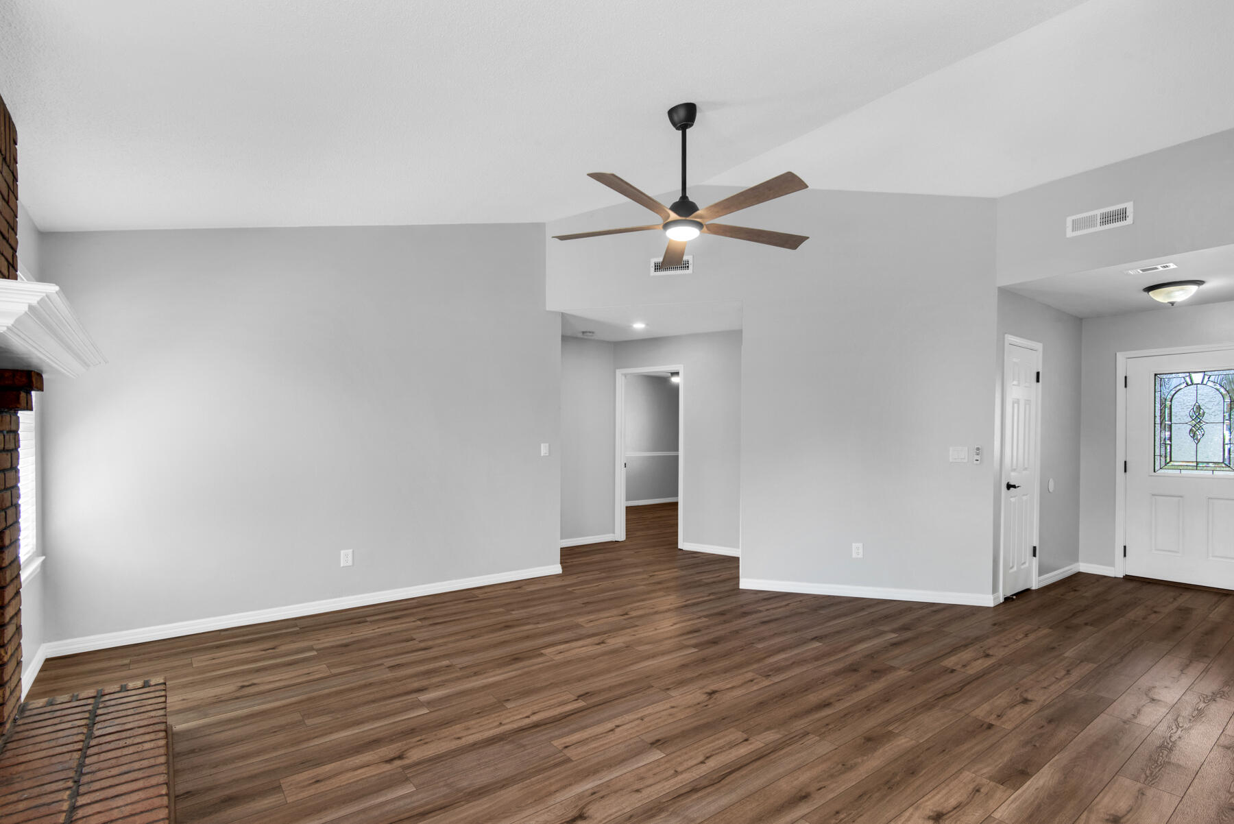 4022 13th Street Niceville, FL 32578 - Photo 7 of 37 a view of an empty room with wooden floor and a ceiling fan