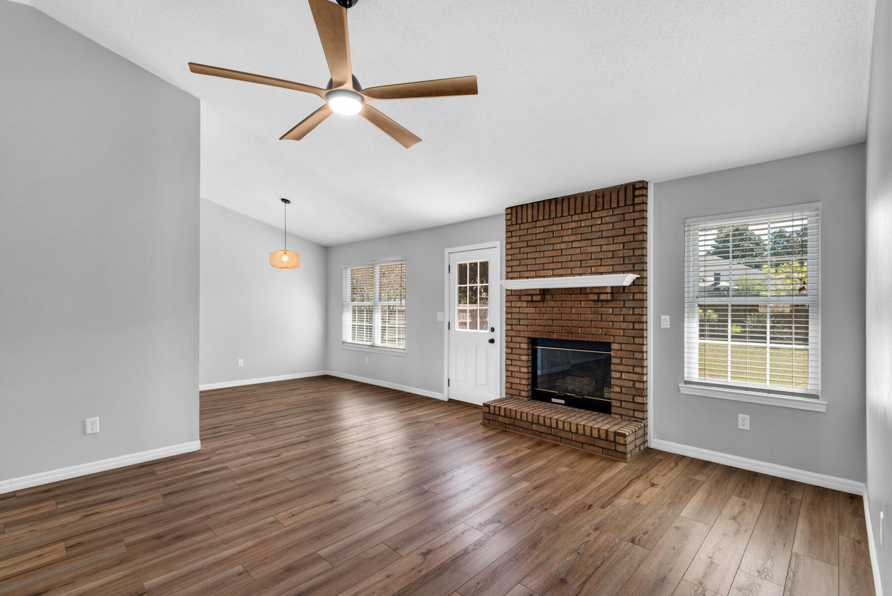4022 13th Street Niceville, FL 32578 - Photo 9 of 37 an empty room with windows fireplace and wooden floor