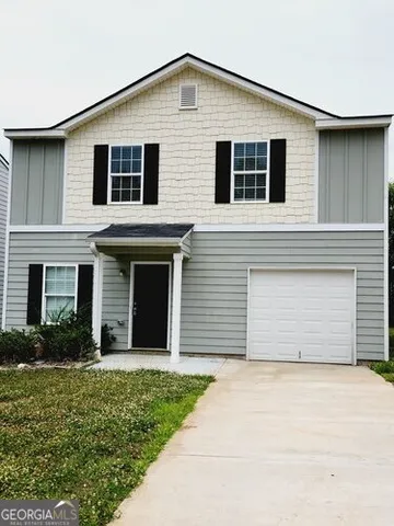 a view of a house with a yard and garage
