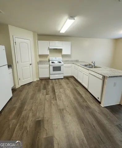 a kitchen with white cabinets and white appliances