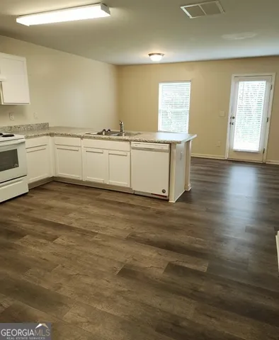 a view of empty room with wooden floor and window